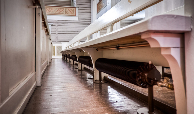 Mäntyharju kyrka finns i Södra Savolax och är Finlands näststörsta träkyrka. Värmeelementen under kyrkbänkarna byggdes i gammaldags stil och i enlighet med musieverkets bestämmelser så att de skulle passa in i den övriga miljön. (foto: Senera oy)