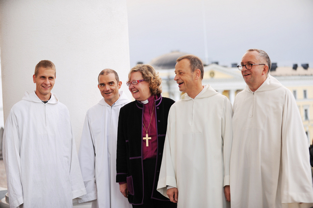 Biskop Irja Askola samtalar med bröderna från Taizé på domkyrkans trappa.