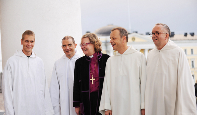 Biskop Irja Askola samtalar med bröderna från Taizé på domkyrkans trappa.